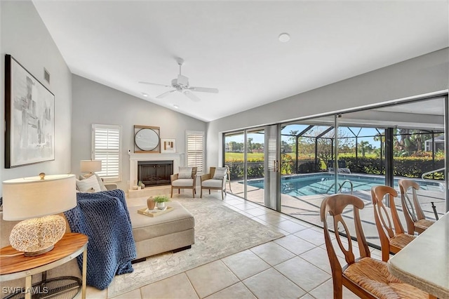 28389 Verde Ln, Bonita Springs, FL 34135 - living area with a ceiling fan, vaulted ceiling, healthy amount of natural light, light tile patterned flooring, and a fireplace
