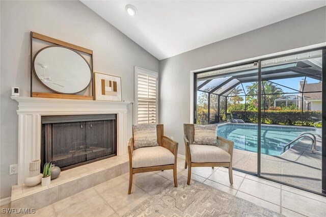 28389 Verde Ln, Bonita Springs, FL 34135 - sitting room with a sunroom, vaulted ceiling, tile patterned floors, plenty of natural light, and a fireplace with raised hearth