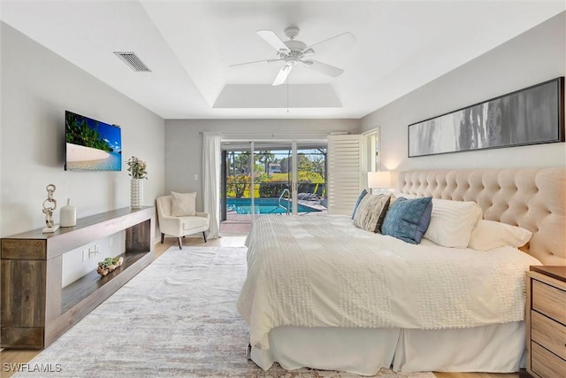 28389 Verde Ln, Bonita Springs, FL 34135 - bedroom with access to exterior, a tray ceiling, wood finished floors, and ceiling fan
