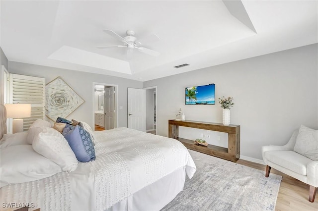 28389 Verde Ln, Bonita Springs, FL 34135 - bedroom with a raised ceiling, wood finished floors, baseboards, a ceiling fan, and connected bathroom