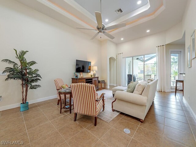 7826 Martino Cir, Naples, FL 34112 - living room with crown molding, light tile patterned floors, baseboards, a raised ceiling, and ceiling fan