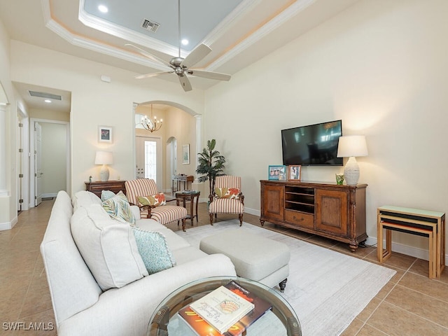 7826 Martino Cir, Naples, FL 34112 - living room featuring visible vents, crown molding, arched walkways, a tray ceiling, and light tile patterned floors
