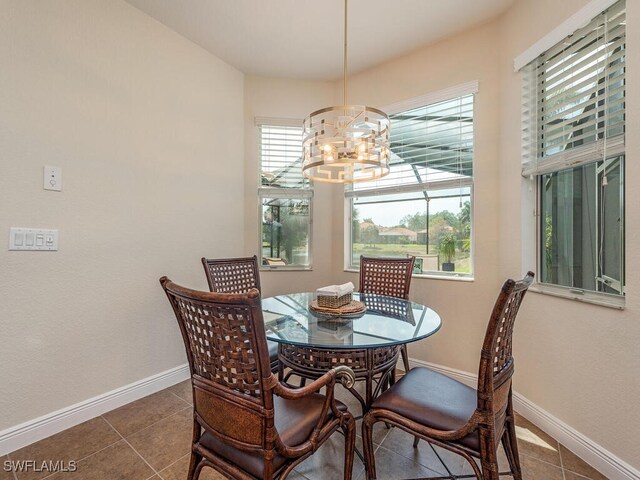 7826 Martino Cir, Naples, FL 34112 - tiled dining space featuring plenty of natural light, baseboards, and an inviting chandelier