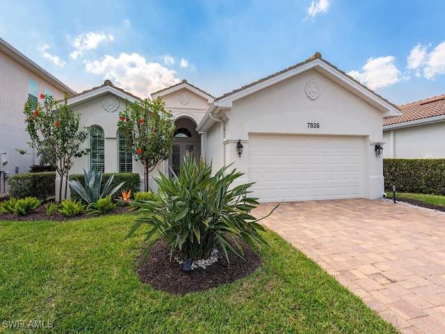 7826 Martino Cir, Naples, FL 34112 - view of front of property with decorative driveway, a front yard, stucco siding, and a garage
