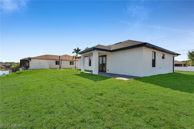 129 NE 5th Ter, Cape Coral, FL 33909 - back of house featuring a lawn, stucco siding, and fence
