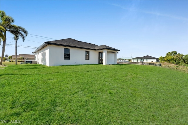 129 NE 5th Ter, Cape Coral, FL 33909 - back of house with a lawn and stucco siding
