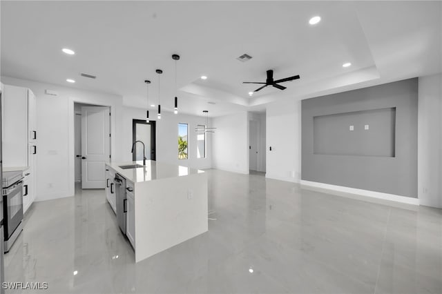 129 NE 5th Ter, Cape Coral, FL 33909 - kitchen featuring a sink, a raised ceiling, white cabinetry, stainless steel appliances, and recessed lighting