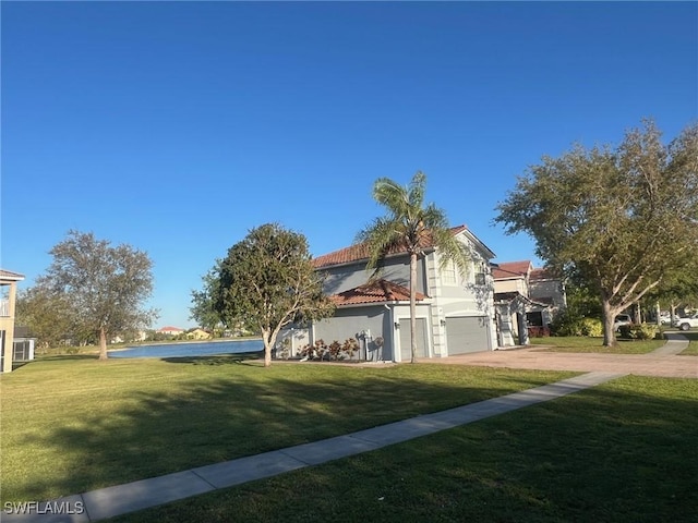 view of home's exterior featuring a water view, driveway, a garage, and a lawn