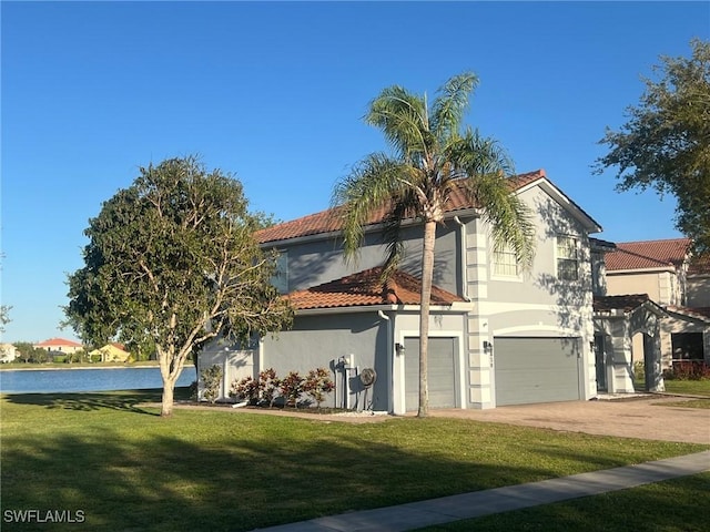 exterior space with driveway, a water view, a tiled roof, a garage, and stucco siding