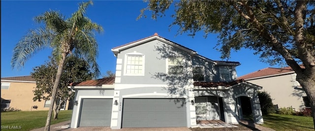 view of front of property with a front yard, driveway, and stucco siding