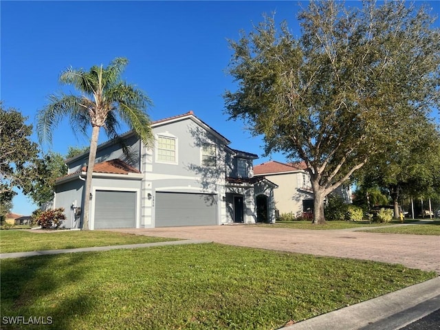 view of front of property with driveway, a front yard, stucco siding, a tiled roof, and a garage