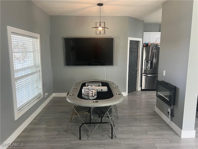 dining area featuring heating unit, wood tiled floor, and baseboards