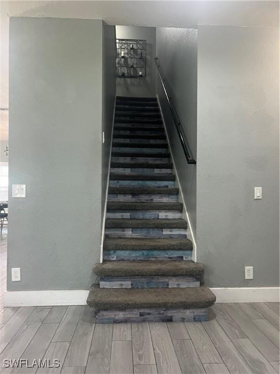 stairs with wood tiled floor and baseboards