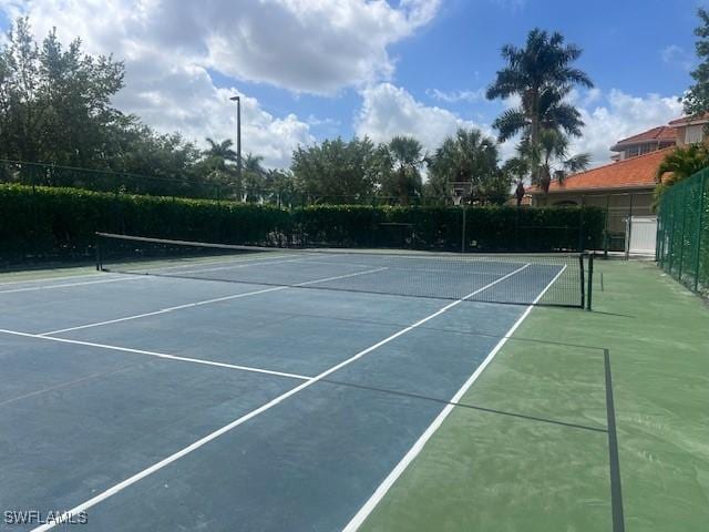 view of tennis court featuring fence