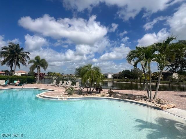 community pool with fence and a patio area