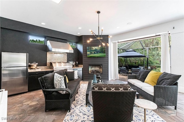 living area featuring a fireplace, an inviting chandelier, recessed lighting, and plenty of natural light