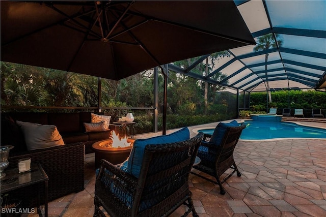 outdoor pool featuring glass enclosure, a patio area, and an outdoor living space with a fire pit