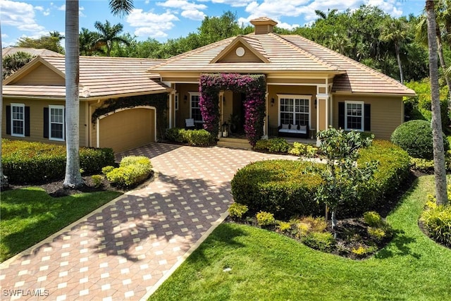 single story home featuring driveway, an attached garage, a chimney, and a tile roof