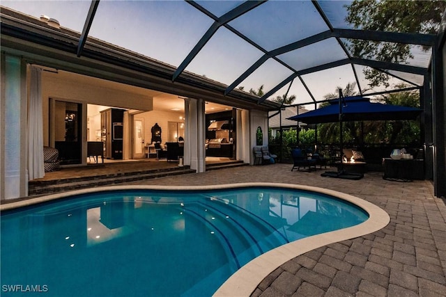 pool at dusk with a patio, a fire pit, and an outdoor pool