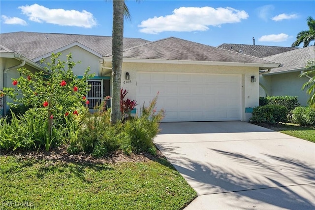 6103 Thresher Dr Unit 102, Naples, FL 34112 - view of front of home with stucco siding, an attached garage, driveway, and a shingled roof