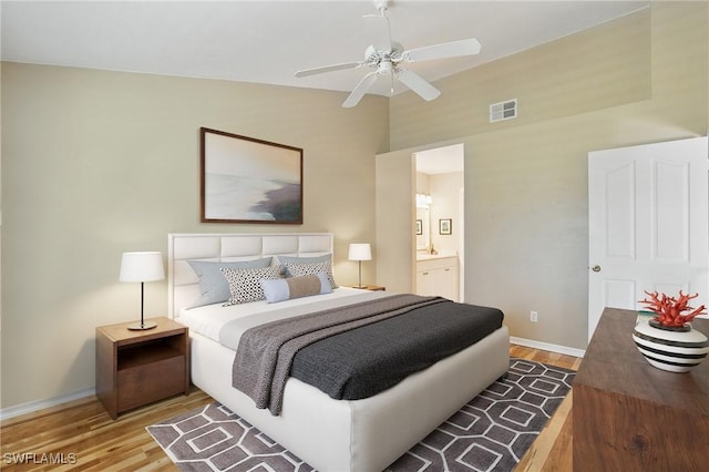 6103 Thresher Dr Unit 102, Naples, FL 34112 - bedroom featuring wood finished floors, vaulted ceiling, ensuite bath, and a ceiling fan