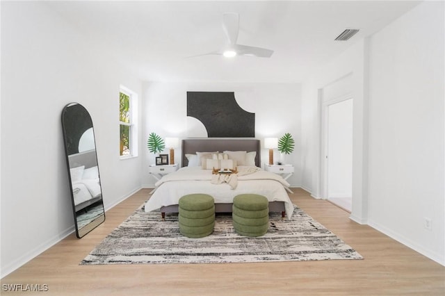 bedroom featuring baseboards, ceiling fan, visible vents, and light wood-type flooring