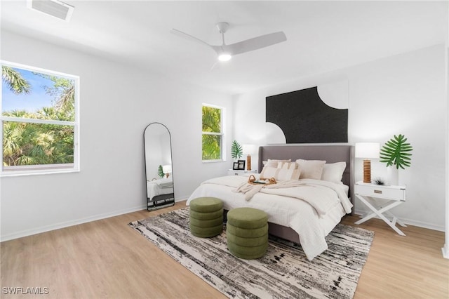 bedroom with baseboards, light wood-type flooring, visible vents, and ceiling fan