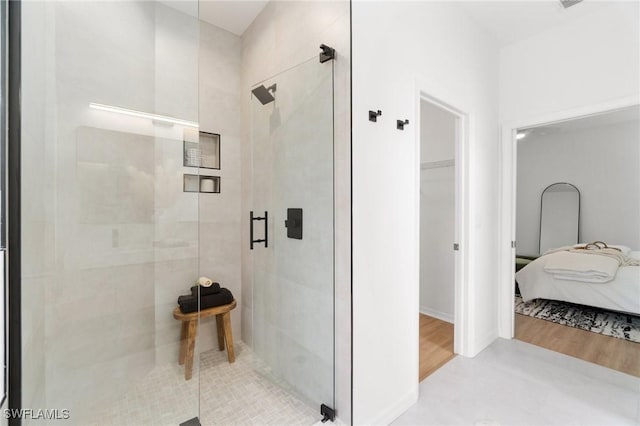bathroom with ensuite bathroom, wood finished floors, and a stall shower