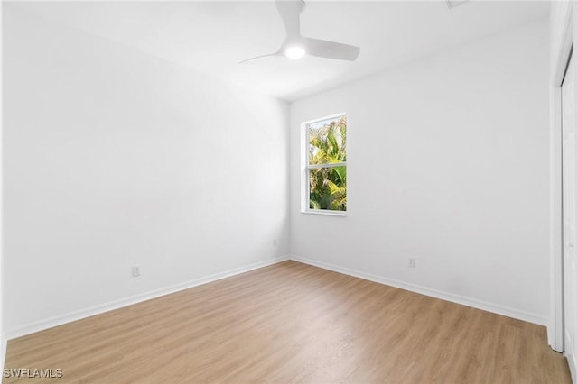 unfurnished room with baseboards, ceiling fan, and light wood-style flooring