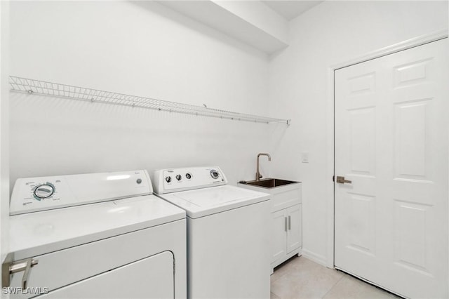 clothes washing area with washing machine and clothes dryer, a sink, light tile patterned floors, and cabinet space