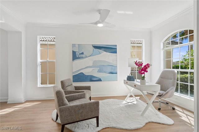 living area with baseboards, wood finished floors, and ornamental molding