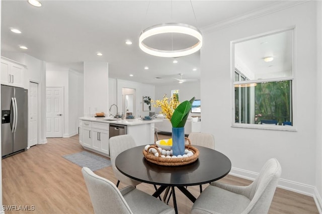 dining room with light wood-style flooring, crown molding, baseboards, and recessed lighting