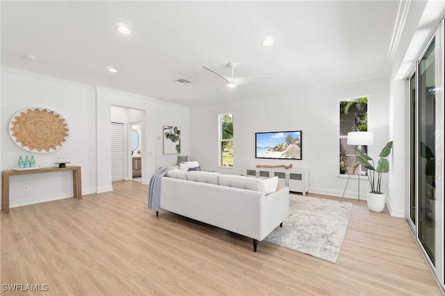 living room with light wood finished floors, baseboards, visible vents, ornamental molding, and recessed lighting