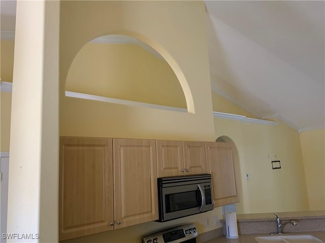 3817 NW 46th St, Cape Coral, FL 33993 - kitchen with stainless steel microwave, a sink, light brown cabinetry, lofted ceiling, and stove