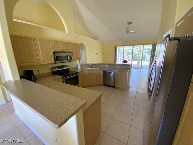 3817 NW 46th St, Cape Coral, FL 33993 - kitchen with stainless steel appliances, a peninsula, light brown cabinetry, light tile patterned floors, and high vaulted ceiling
