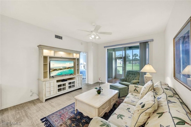 living room featuring visible vents, baseboards, a ceiling fan, and wood finished floors