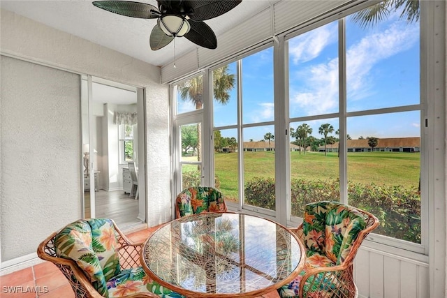 sunroom / solarium with outdoor dining space and ceiling fan