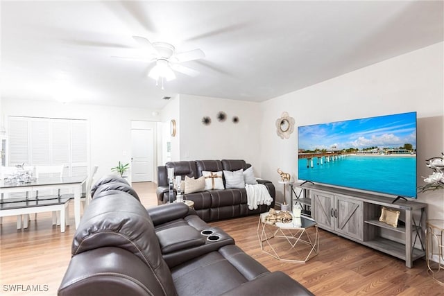 living area featuring visible vents, ceiling fan, and wood finished floors