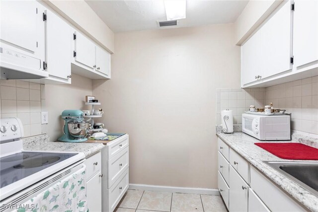 kitchen featuring white cabinets, white appliances, baseboards, tasteful backsplash, and light tile patterned floors