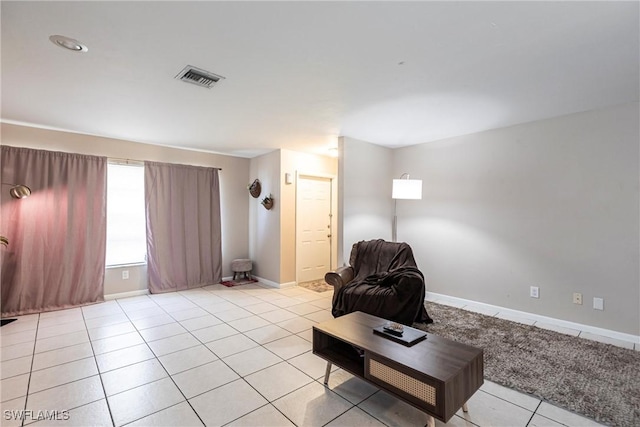 living area with baseboards, visible vents, and light tile patterned floors