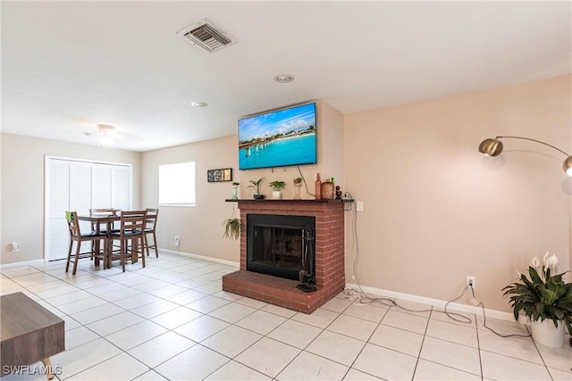 living area with light tile patterned floors, a brick fireplace, baseboards, and visible vents