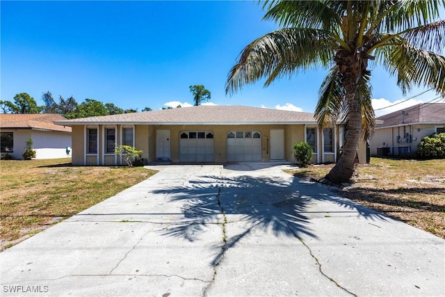 ranch-style home with stucco siding, driveway, a garage, and a front lawn