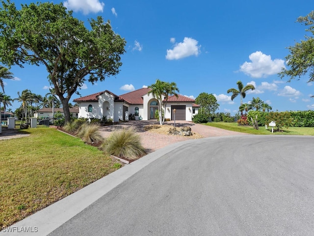 866 Cal Cove Dr, Fort Myers, FL 33919 - mediterranean / spanish house featuring stucco siding, decorative driveway, an attached garage, a front lawn, and a tiled roof