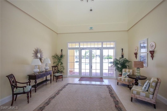 14543 Abaco Lakes Dr Unit 103, Fort Myers, FL 33908 - sitting room with light tile patterned floors, baseboards, and a towering ceiling