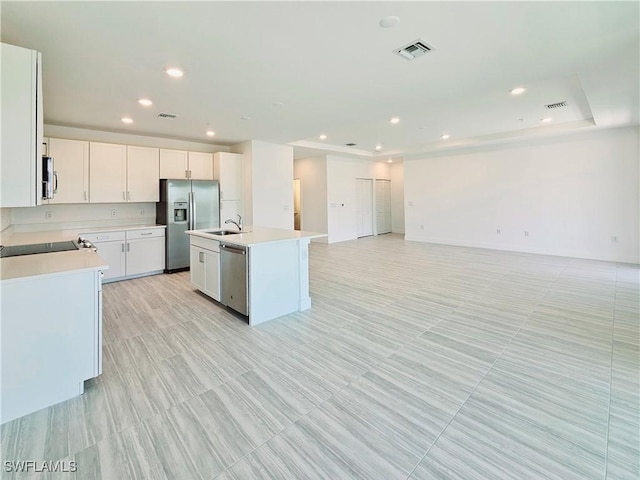 kitchen featuring visible vents, appliances with stainless steel finishes, a sink, light countertops, and open floor plan