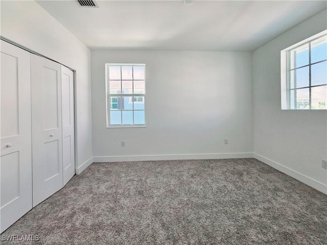 unfurnished bedroom featuring a closet, baseboards, and carpet floors