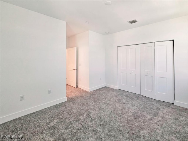 unfurnished bedroom with visible vents, baseboards, a closet, and carpet floors