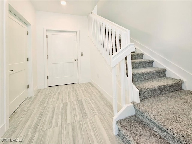 stairway with baseboards and recessed lighting