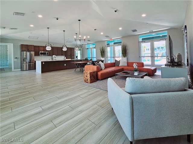 living area with recessed lighting, visible vents, light wood-type flooring, and french doors