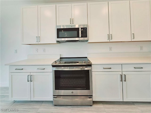 26330 Coco Cay Cir Unit 201, Bonita Springs, FL 34135 - kitchen with appliances with stainless steel finishes, light countertops, and white cabinetry